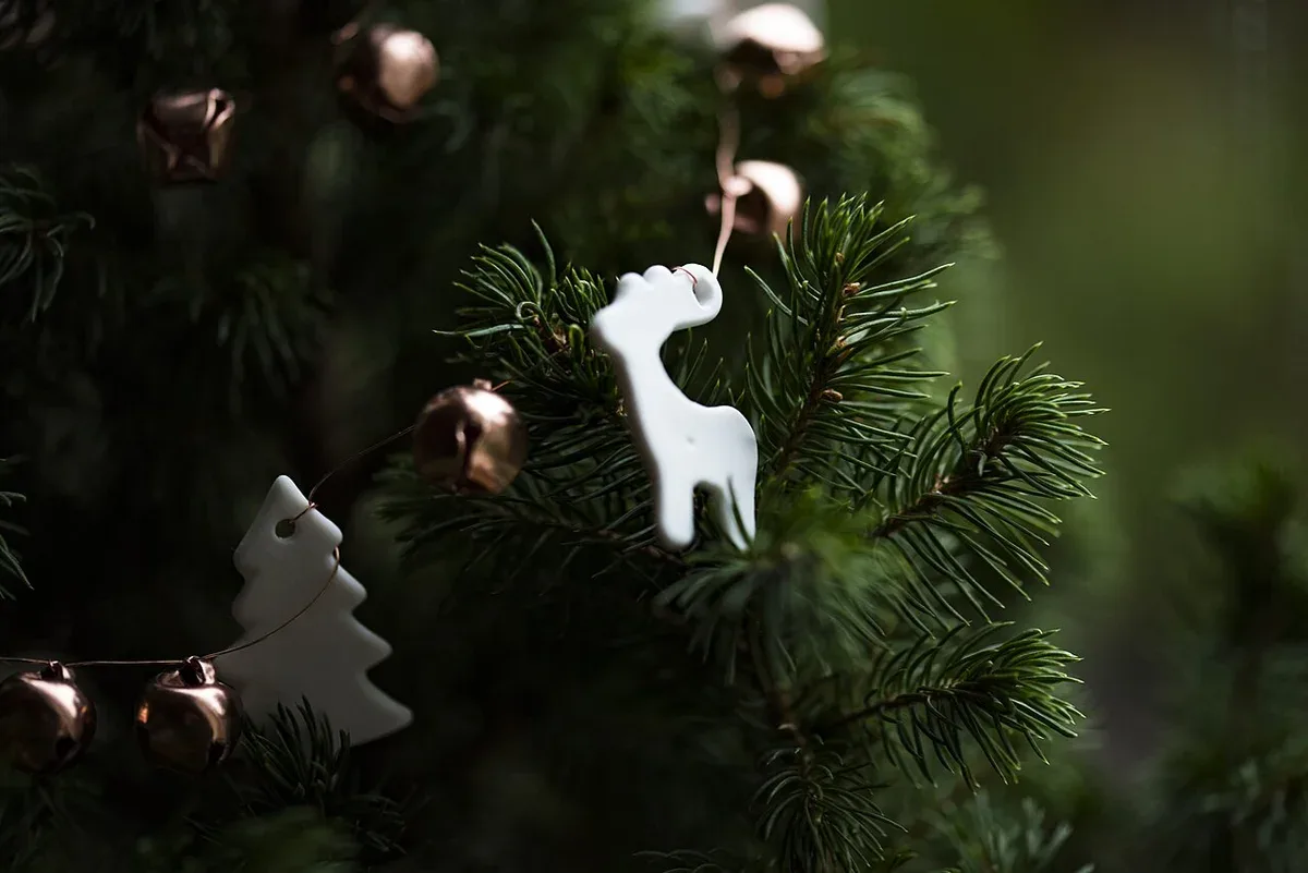 Kleine helle Anhänger an einem dunkelgrünen Weihnachtsbaum