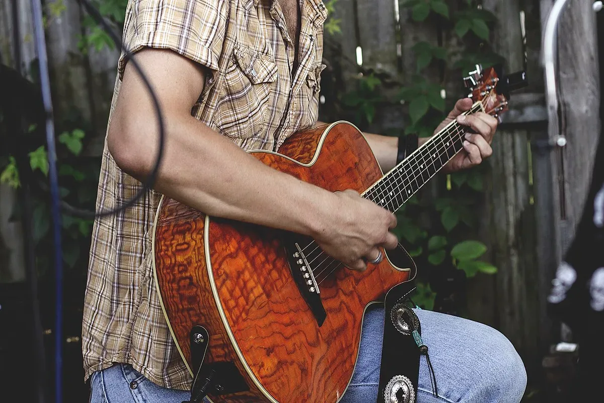 A person playing a stringed instrument outdoors