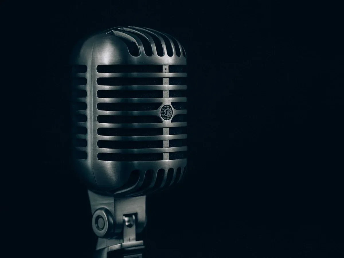 A silver microphone against a dark background